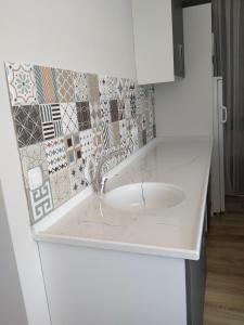 切什梅VENÜS PARK APART SUİTES的厨房里的一个白色水槽,墙上有瓷砖