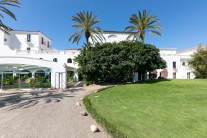 卡皮塔纳Sighientu Resort的一座种植了棕榈树的大型白色建筑和一座庭院