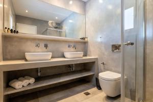 克里希阿克提Golden Beach Hotel的一间带两个盥洗盆和淋浴的浴室