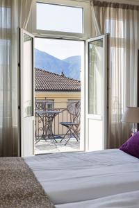 洛迦诺亚历山德拉酒店的一间卧室配有一张床,享有庭院的景色