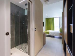 大加那利岛拉斯帕尔马斯Hotel MG Poniente的带淋浴的浴室和1间带1张床的卧室