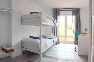 艾利亚德亚罗萨Apartamento Rosalía的一间卧室设有两张双层床和一扇窗户。