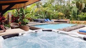 福尔图纳Tifakara Boutique Hotel & Birding Oasis的后院的热水浴池,带游泳池