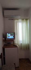 沃迪切DVOKREVETNA SOBA SA KUPAONICOM的一间配有电视的窗户客房