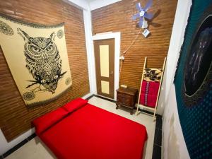 日惹Omah Tukangan Homestay的一间设有红色沙发的房间和墙上的猫头鹰