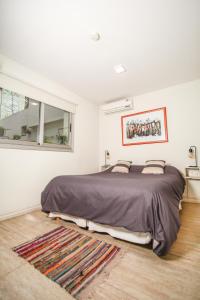 门多萨哈克美特侣旅舍的一间卧室设有一张大床和一个窗户。