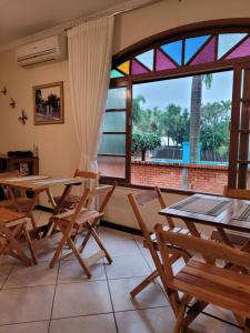 格拉瓦塔尔Pousada Bella Vista的客房设有桌椅和大窗户。