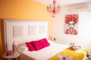 贝尼萨Hostal La Fonda Grupo Terra de Mar, alojamientos con encanto的一间卧室配有一张带红色枕头的床和一幅画