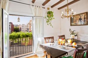 巴塞罗那埃伊桑普雷康福特公寓的一间带桌子和大窗户的用餐室