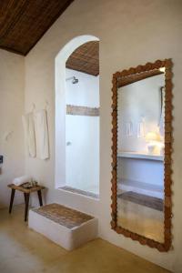 普拉亚埃斯佩洛Hotel Calá & Divino的浴室设有镜子、长凳和水槽