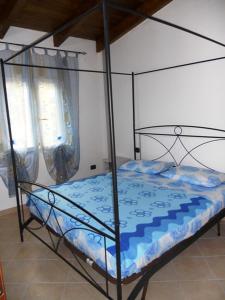 圣玛丽亚Apartment Da Mario的卧室内的金属床和蓝色棉被