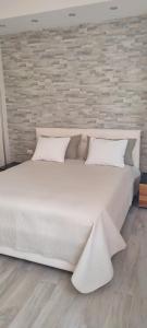 维耶斯泰Dimora Il Tulipano的砖墙房间内一张大白色的床