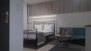 拉里萨Studio V3st & Parking的一间卧室配有一张床、一张桌子和一张沙发