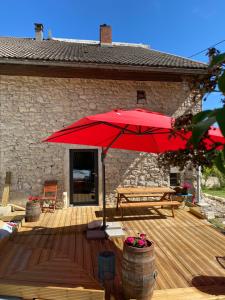EchallonL'instant présent的一个带红色遮阳伞和长凳的木制甲板
