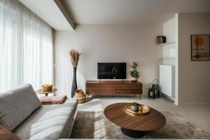 科克赛德- Carijoca - Gemoderniseerd, lichtrijk & zijdelings zeezicht app的带沙发和咖啡桌的客厅