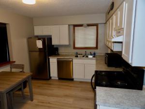 WashburnThe Washburn Inn的厨房配有白色橱柜和不锈钢冰箱