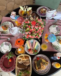 沙帕达-杜斯吉马朗伊斯Pousada Vilagio Chapada的一张桌子,上面放着食物和鲜花