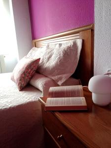 普雷列索Pensión QuintAna的一张带木制梳妆台的床,上面有一本书