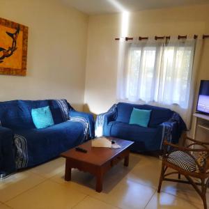 布希奥斯Chale Buzios Praia Rasa的客厅配有2张蓝色沙发和1张咖啡桌