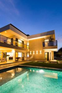 卡诺格布拉达LUXURIOUS NEW HOUSE, UNFORGETABLE EXPERIENCE.的一座大房子,前面设有一个游泳池
