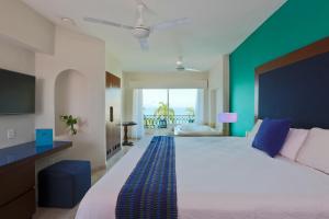 巴亚尔塔港Crown Paradise Golden All Inclusive Resort - Adults Only的一间卧室设有一张大床和绿色的墙壁