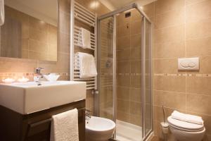 加尔达湖滨Hotel Portici - Romantik & Wellness的浴室配有盥洗盆、卫生间和淋浴。