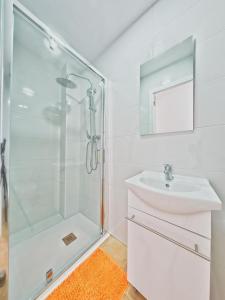 Mareny BarraquetasCASA EN LA PLAYA VALENCIA EL PERELLO的白色的浴室设有水槽和淋浴。
