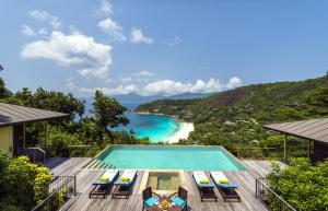 马埃岛贝拉扎尔区塞舌尔四季酒店的享有带椅子的游泳池和海滩的景色