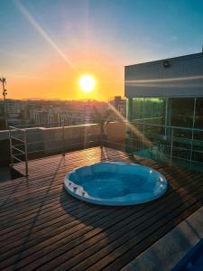 卡波布里奥帕拉迪索公司酒店的甲板上的热水浴池,享有日落美景