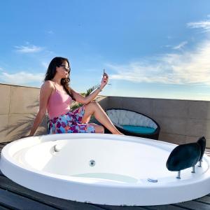 卡波布里奥帕拉迪索公司酒店的坐在浴缸里照相的女人