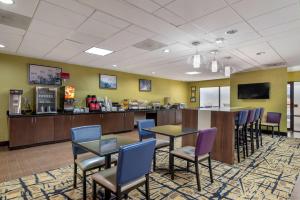 麦克多诺Best Western Plus McDonough Inn & Suites的一间设有桌椅和柜台的等候室