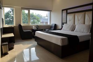 钱德加尔皇家公园22酒店的一间卧室配有一张大床和一张桌子及椅子
