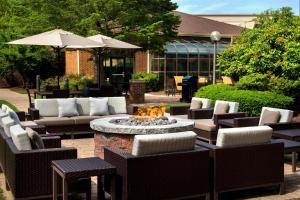 米尔福德波士顿米尔福德万怡酒店的庭院设有火坑、椅子和遮阳伞