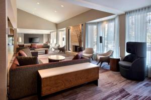 米尔福德波士顿米尔福德万怡酒店的客厅配有沙发、椅子和电视