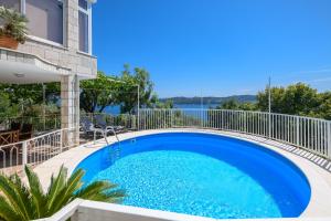 奥拉萨奇Apartment MARIO - veliki stan za odmor - terasa- vrt - bazen - pogled more, izoliran的一个带白色围栏的大型蓝色游泳池