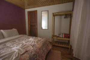 维奥康德马奥Chalés Cerejeira的一间卧室配有一张床和镜子