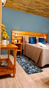 大普拉亚Pousada Recanto dos Canyons的一间卧室配有两张带蓝色枕头和桌子的床