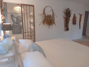 Rodrigues Island玛米切丽山林小屋的卧室配有白色的床,墙上挂着一幅画