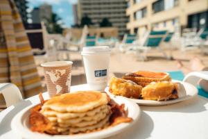 檀香山威基基智选假日酒店 的一张桌子,上面有两盘早餐食品