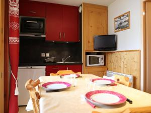 欧苏瓦Studio Aussois, 1 pièce, 4 personnes - FR-1-508-270的厨房配有红色橱柜的桌子