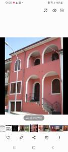 IttiriAffittacamere Su Padru的粉红色的建筑,设有窗户和阳台