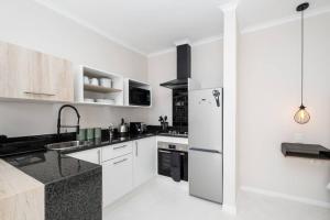 约翰内斯堡31OnGambia的厨房配有白色橱柜和不锈钢冰箱