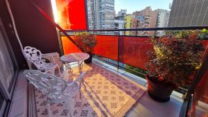 科尔多瓦Departamento de los Boulevares的阳台配有两把椅子和一张桌子,种有植物