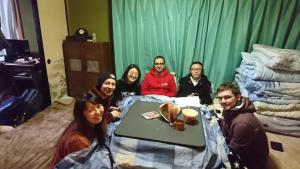 系鱼川市非水的海咖啡厅旅馆的一群人坐在一个房间里桌子旁