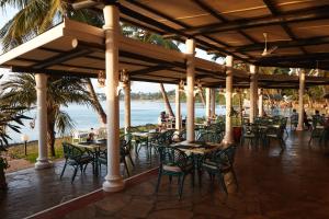蒙巴萨Tamarind Village Hotel Apartments的海滩上带桌椅的餐厅