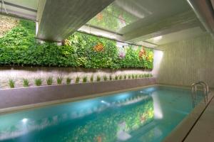 雅典COCO-MAT Athens Jumelle的墙上设有垂直花园的游泳池