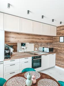 沃鲁Ranna Apartment的厨房配有白色橱柜和木墙