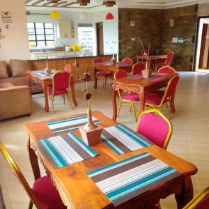 基塔莱Stay.Plus Villa Serene Kitale的用餐室配有木桌和椅子