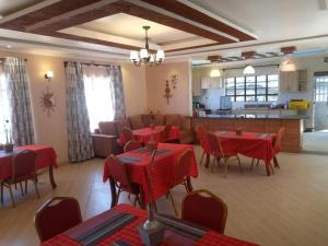 基塔莱Stay.Plus Villa Serene Kitale的一间带红色桌椅的餐厅和一间厨房