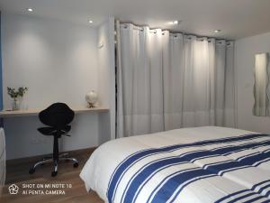 贝尔热拉克Appartement de charme en plein coeur de Bergerac的卧室配有床、椅子和窗户。